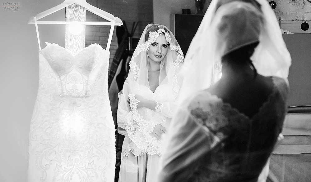 невеста рядом со своим платьем