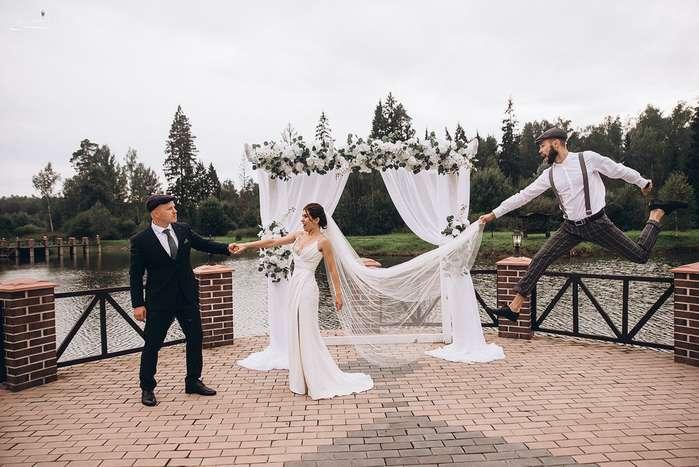 свадебный ведущий прыгает с платьем невесты