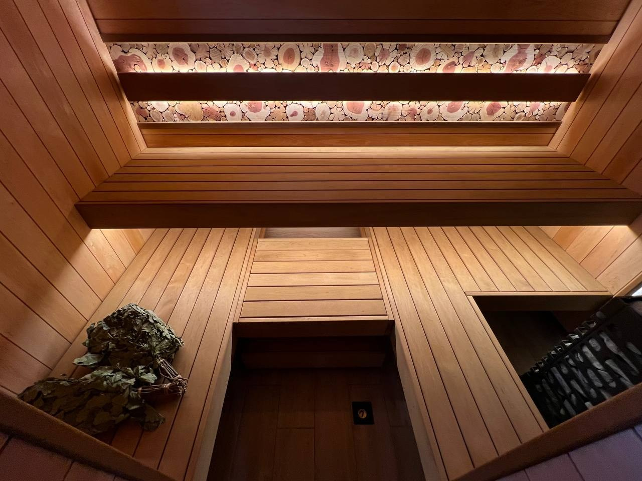 Семейная баня в Рощино из ольхи с можжевеловым панно, яркой печной зоной, закарнизной подсветкой и печью от производителя Aston. SaunaTopMasters