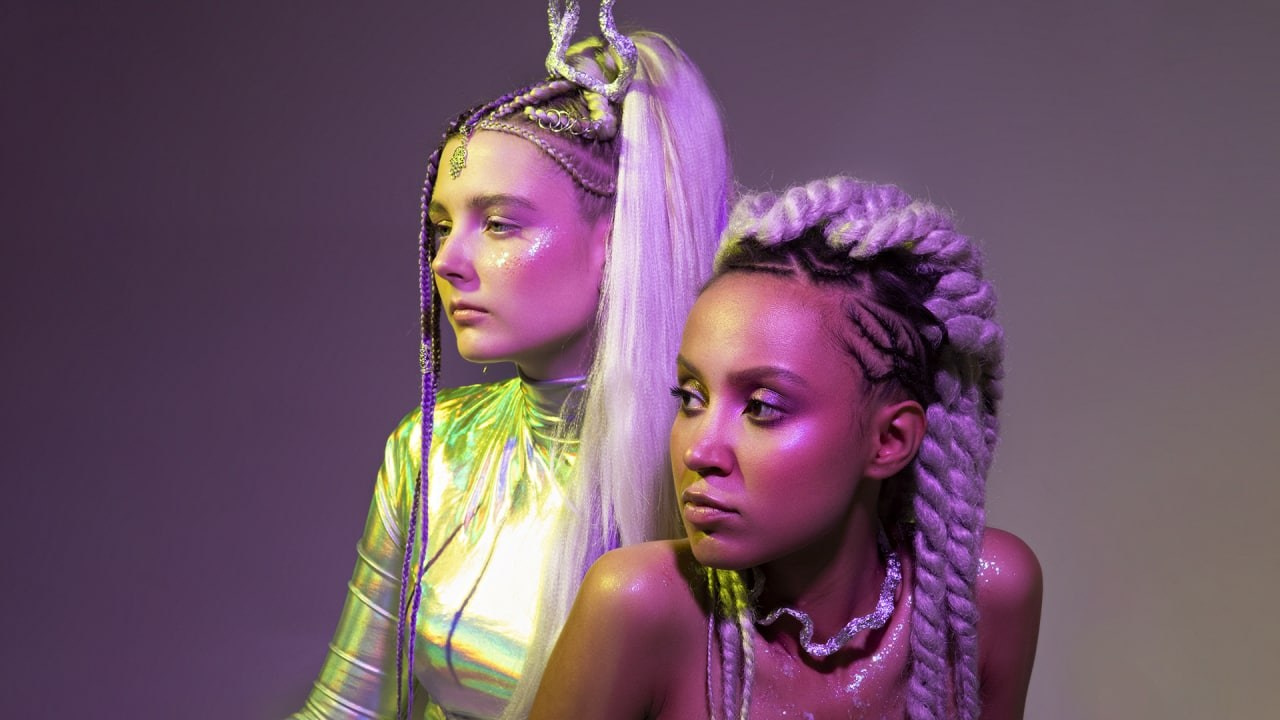 Космическая фотосессия двух девушек в ярких образах на фоне неона.