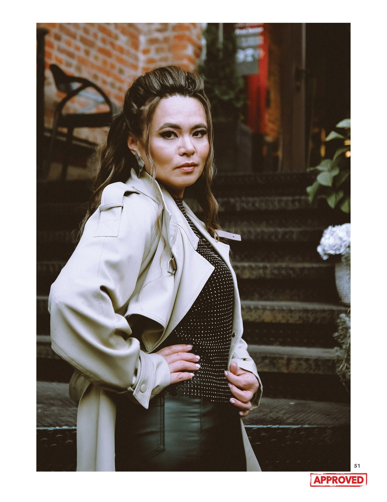 На фото девушка стоит на лестнице и смотрит в сторону.