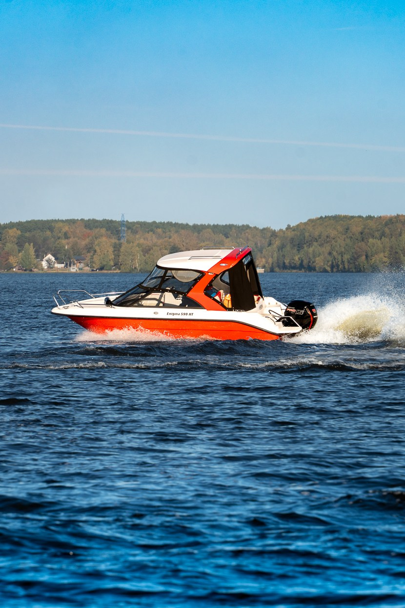 Красный катер Enigma в лучах заката, движение по воде