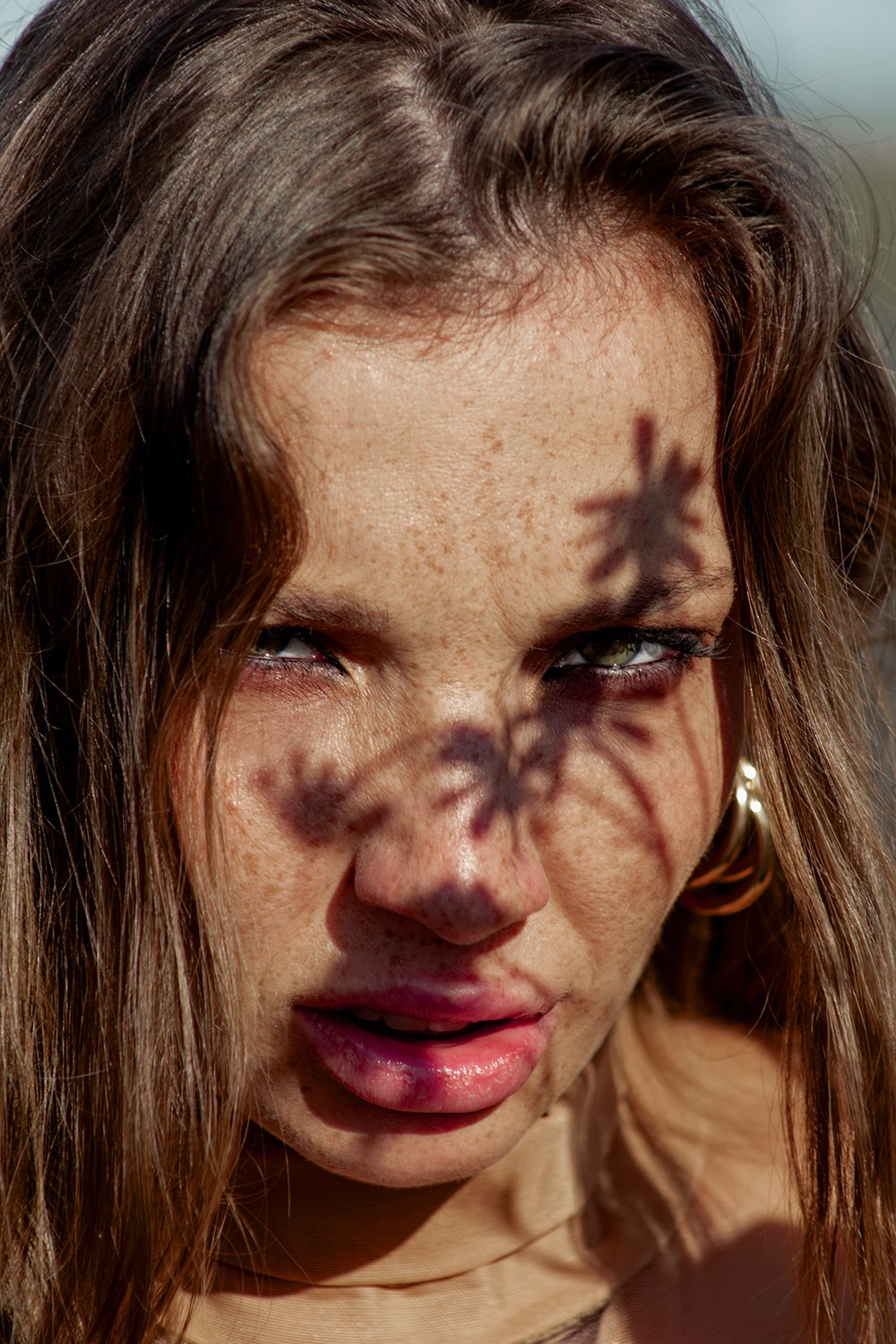 Портрет девушки с тенью на лице на улице