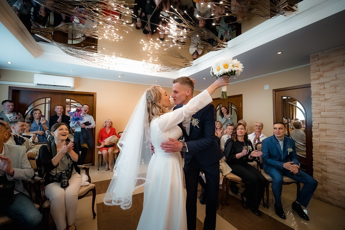 Жених и невеста целуются во время регистрации брака в ЗАГСе на Васильевском острове в Санкт-Петербурге. Горизонтальный поясной кадр.