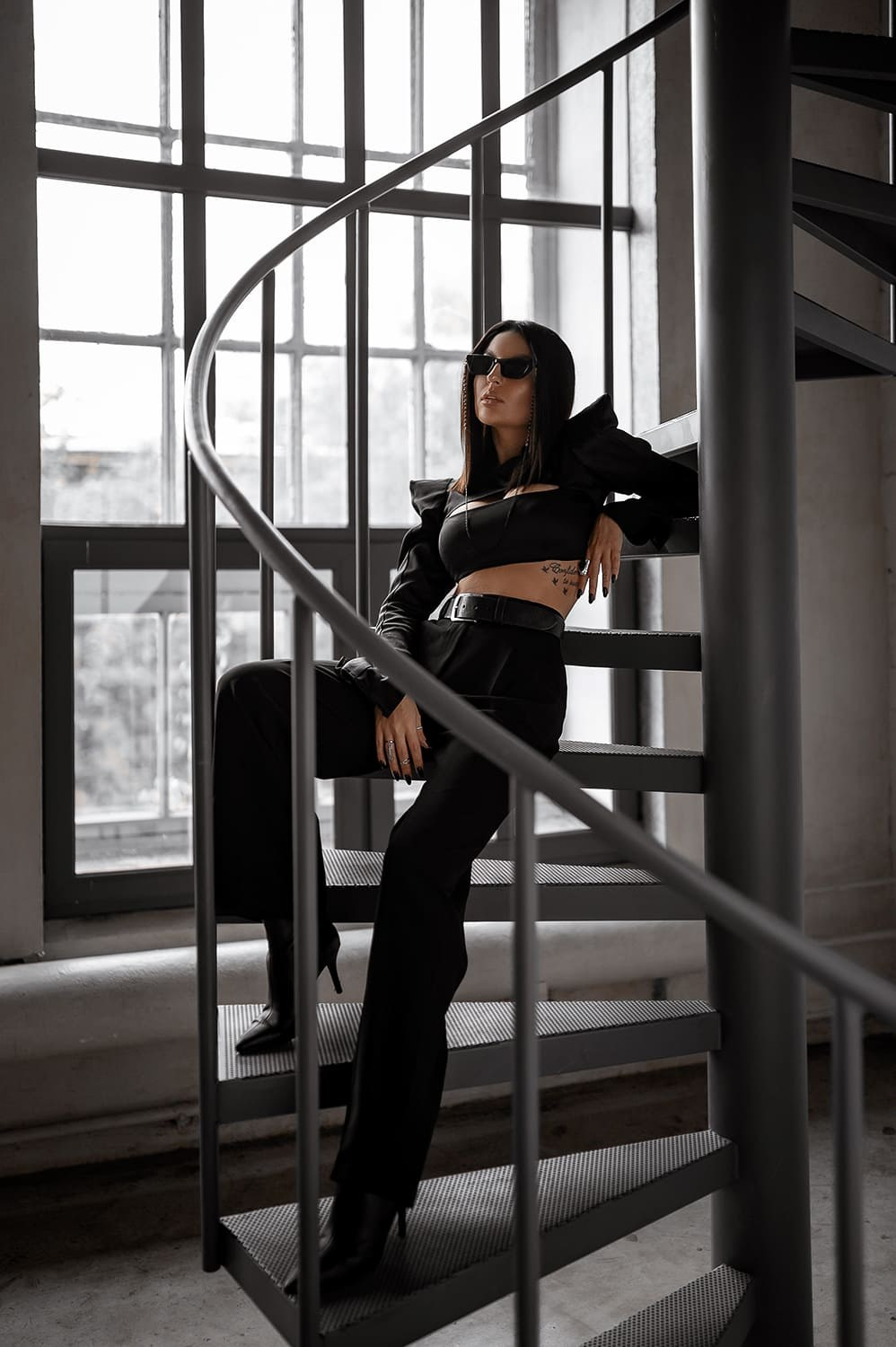 Модель в чёрном на спиральной лестнице