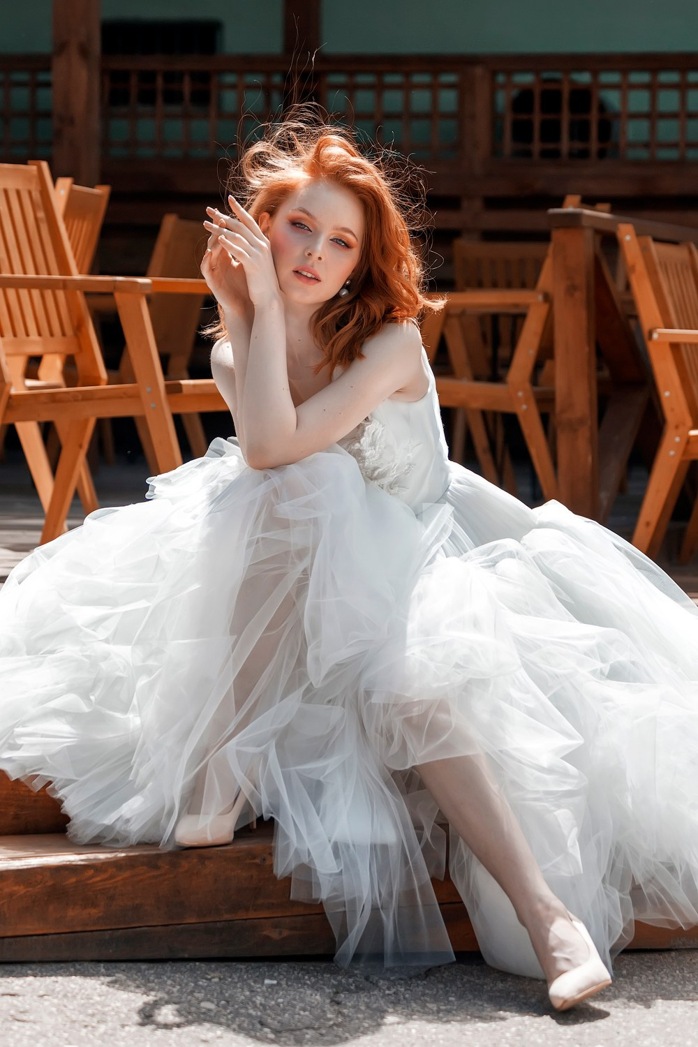 Невеста задумчиво сидит на сцене в летнем кафе - фотограф Янкаускене Наталья