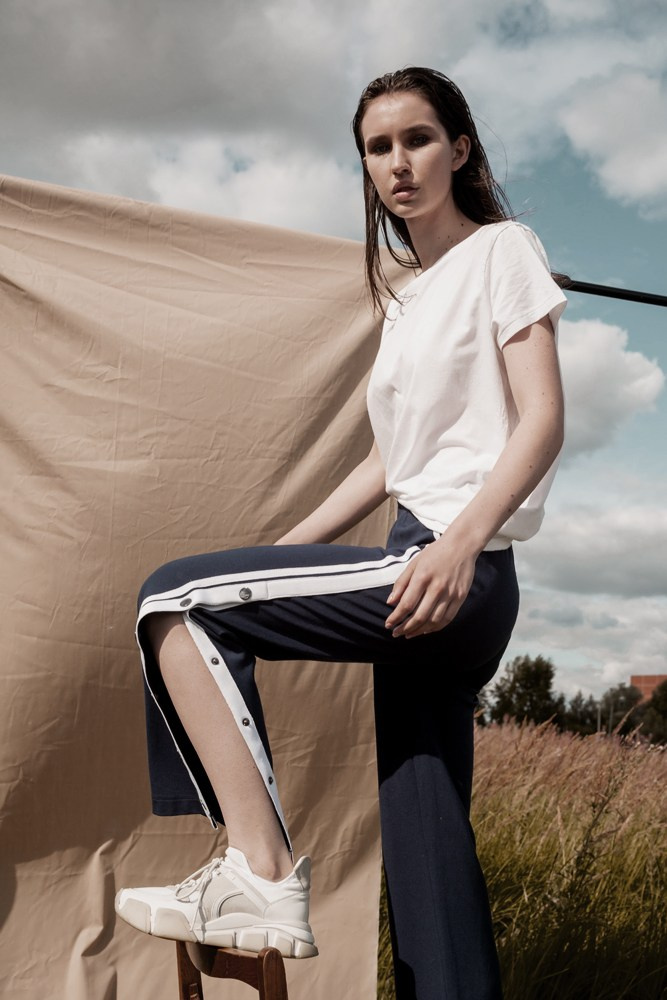 Девушка в спортивных штанах на природе на фоне ткани