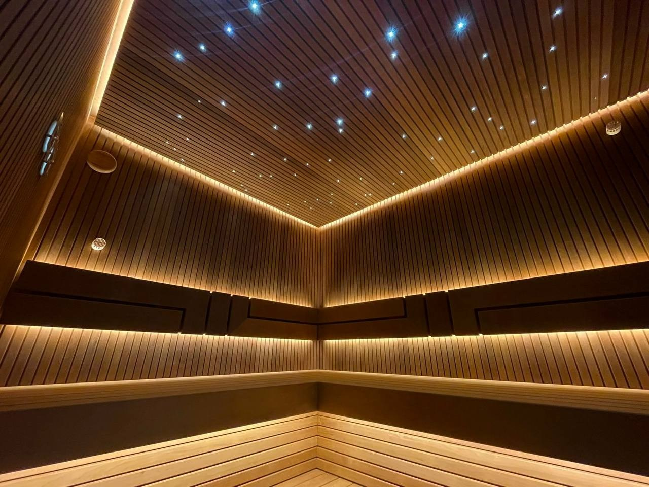 Сауна на Медном Озере из термоольхи «рейка», с тёплой подсветкой, звёздным небом и эффектным IKI Monolith на фоне итальянского камня. SaunaTopMasters