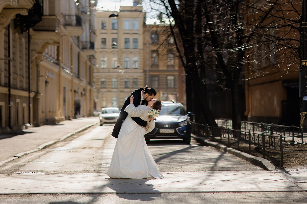 Жених и невеста обнимаются на улице Санкт-Петербурга