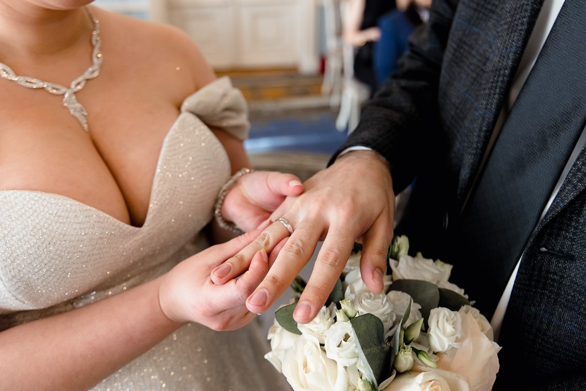 Невеста надевает кольцо жениху в зале регистраций в ЗАГСе на фурштатской СПб. Крупный план. Горизонтальный кадр