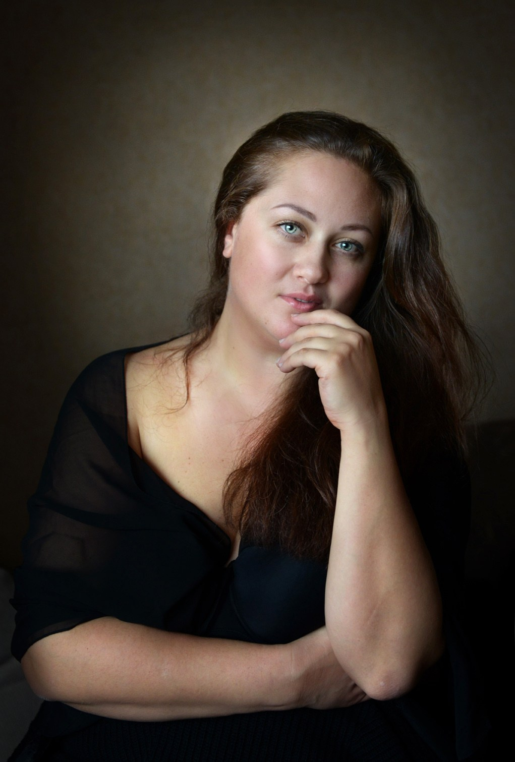 Художественный портрет белокожей голубоглазой женщины в черном платье с распущенными волосами