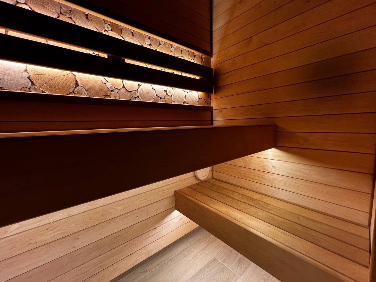 Уютная парная в Glorex Заневский. Компактная, но визуально просторная за счет парящих полков и горизонтального расположения светлой ольхи. SaunaTopMasters