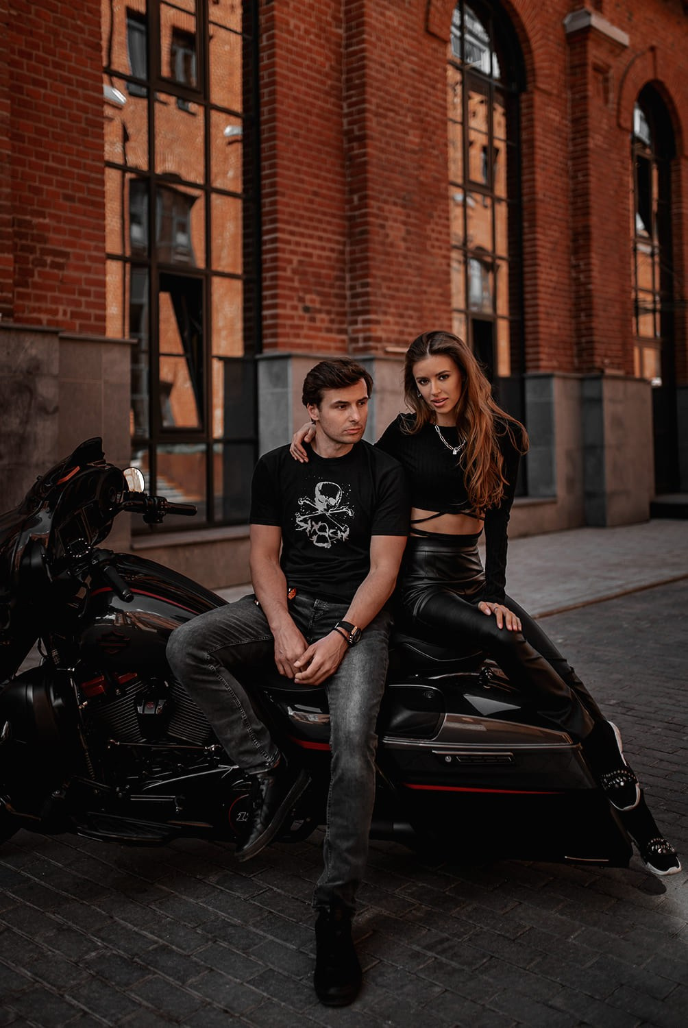 Пара сидит на мотоцикле на улице во время лав стори фотосессии