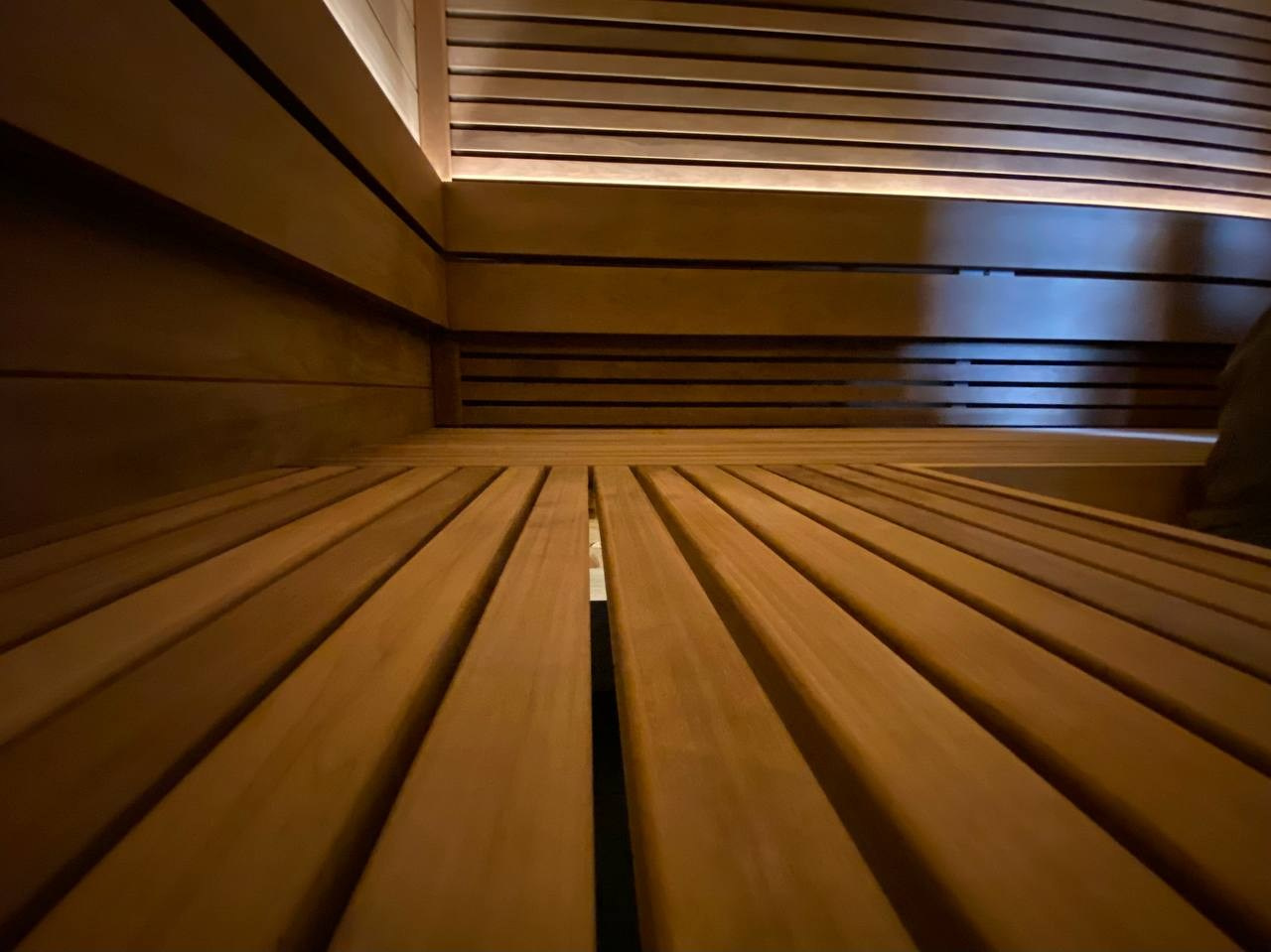 Сауна в селе Былово из термоосины: парящий потолок с подсветкой и скрытая электрокаменка с функцией залива воды — стильно и смело. SaunaTopMasters