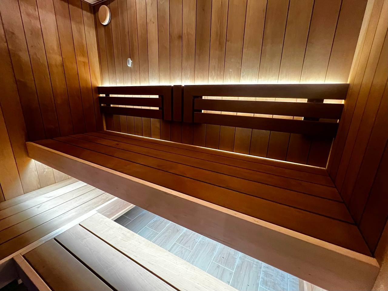 Сауна в Рощино на базе электрокаменки с парогенератором Harvia Virta выполнена из термоольхи с интеграцией световых линий из можжевельника. SaunaTopMasters