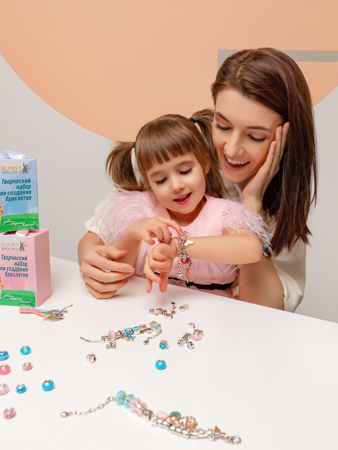 На столе как готовые браслеты, так и отдельные разноцветные бусины.