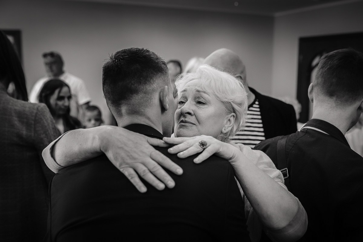 гости поздравляют молодожёнов во время регистрации брака в ЗАГСе на Васильевском острове в Санкт-Петербурге.  Горизонтальный крупный кадр. Чёрно-белый кадр.