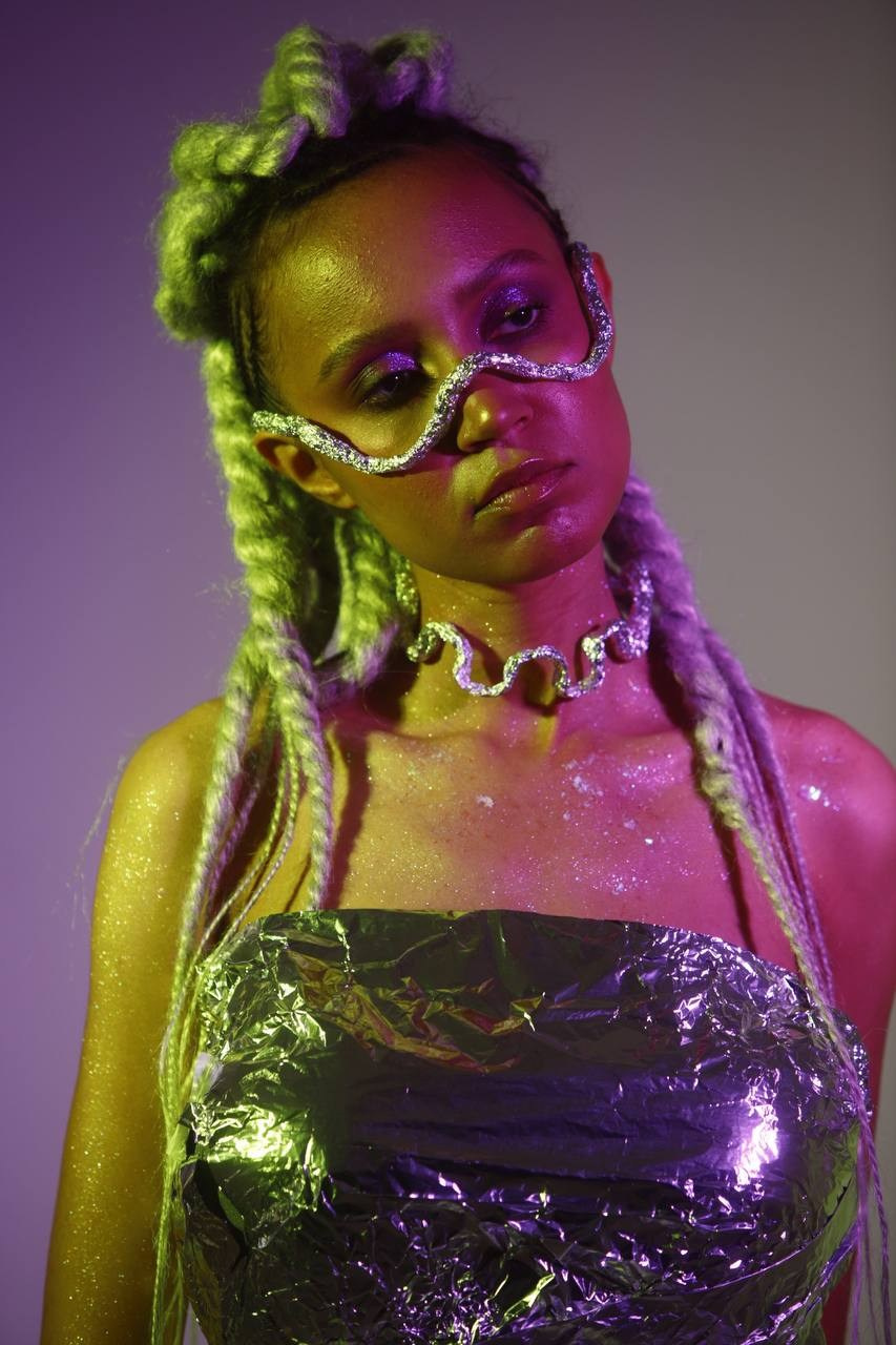 Космическая фотосессия девушки в серебристом топе и жёлтых очках.