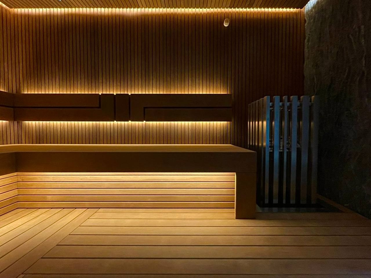 Сауна на Медном Озере из термоольхи «рейка», с тёплой подсветкой, звёздным небом и эффектным IKI Monolith на фоне итальянского камня. SaunaTopMasters