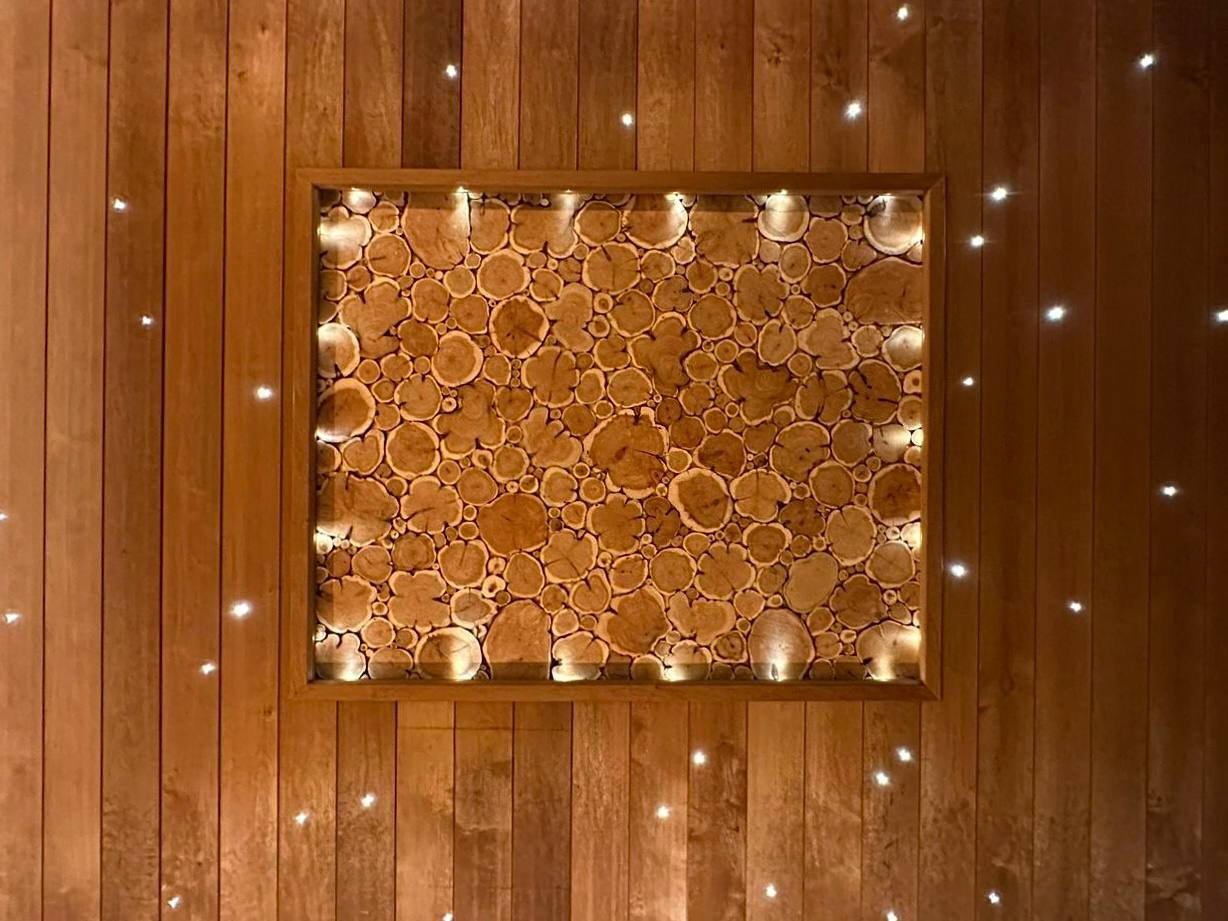 Брутальная парная в Озерках выполнена из термоольхи 135 мм. А среди звездного неба красуется панно из срезов можжевельника. SaunaTopMasters