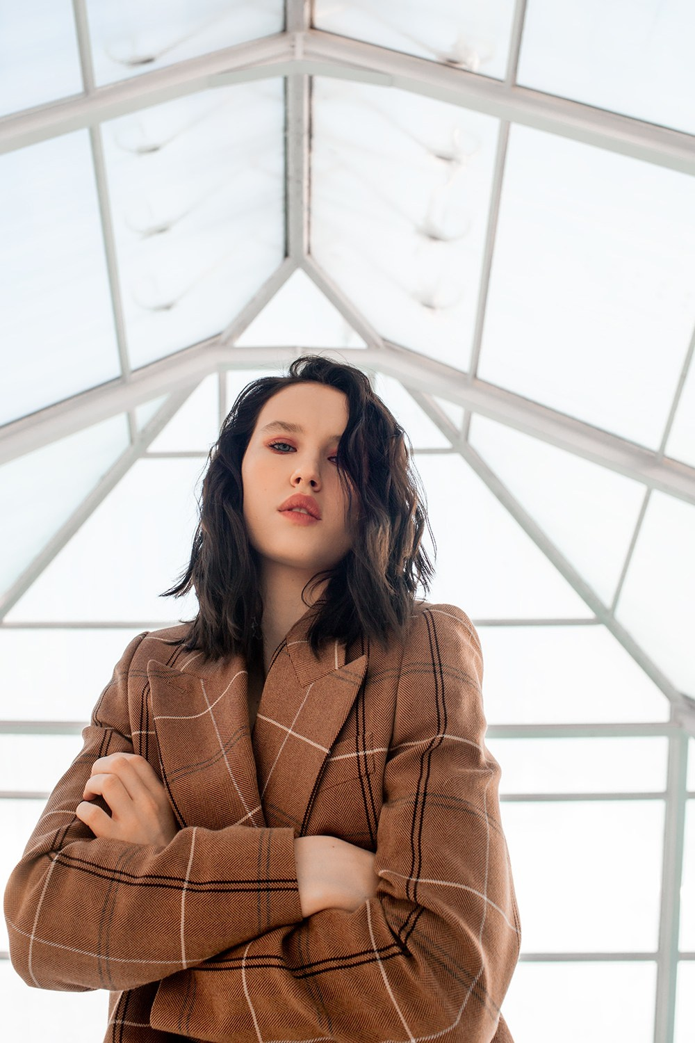 Портрет девушки ракурс снизу на фоне прозрачной крыши