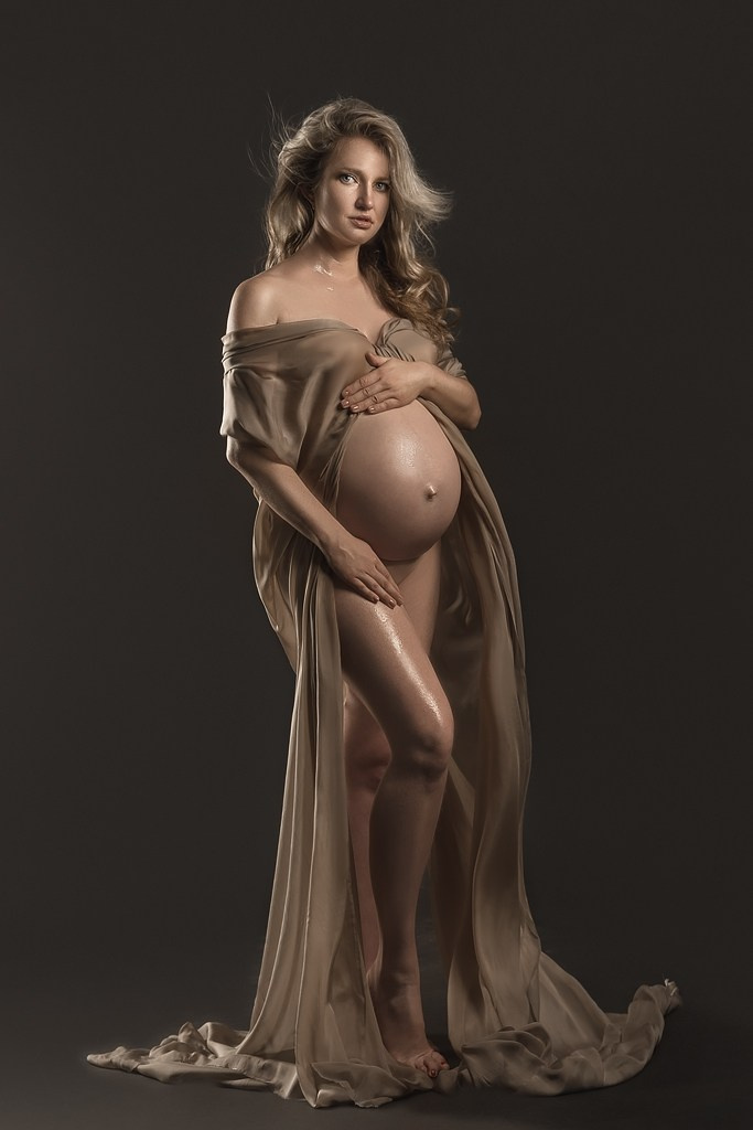 фотосессия беременной в фотостудии на темном фоне в красивом разлетающемся платье, фотография беременности, фотосессия беременных, портрет беременной