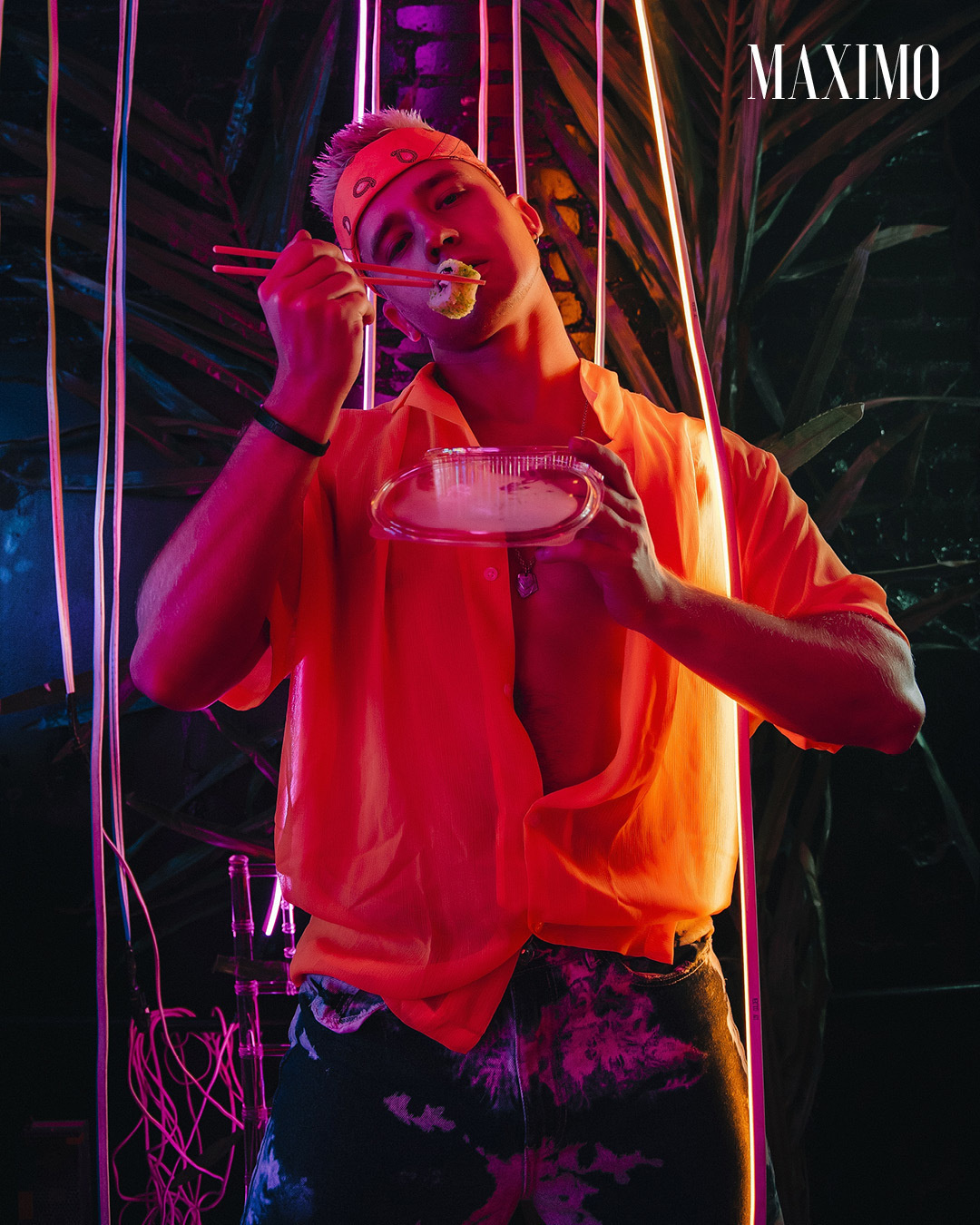 Парень в желтой рубашке ест суши.