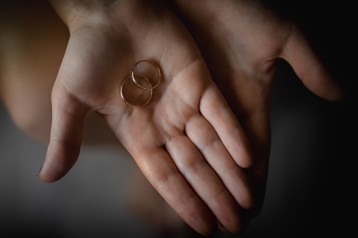 Кольца молодожёнов на ладони в комнате в Санкт-Петербурге