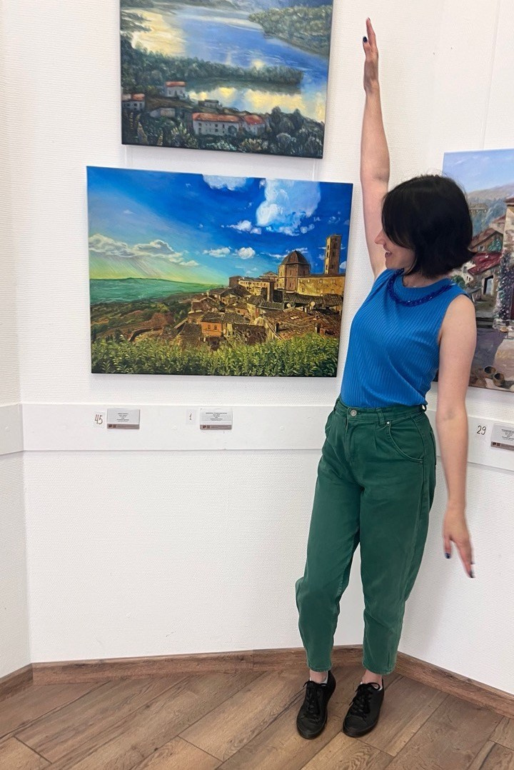 коллективная выставка картин с пейзажами италии, художник стоит перед своей картиной
