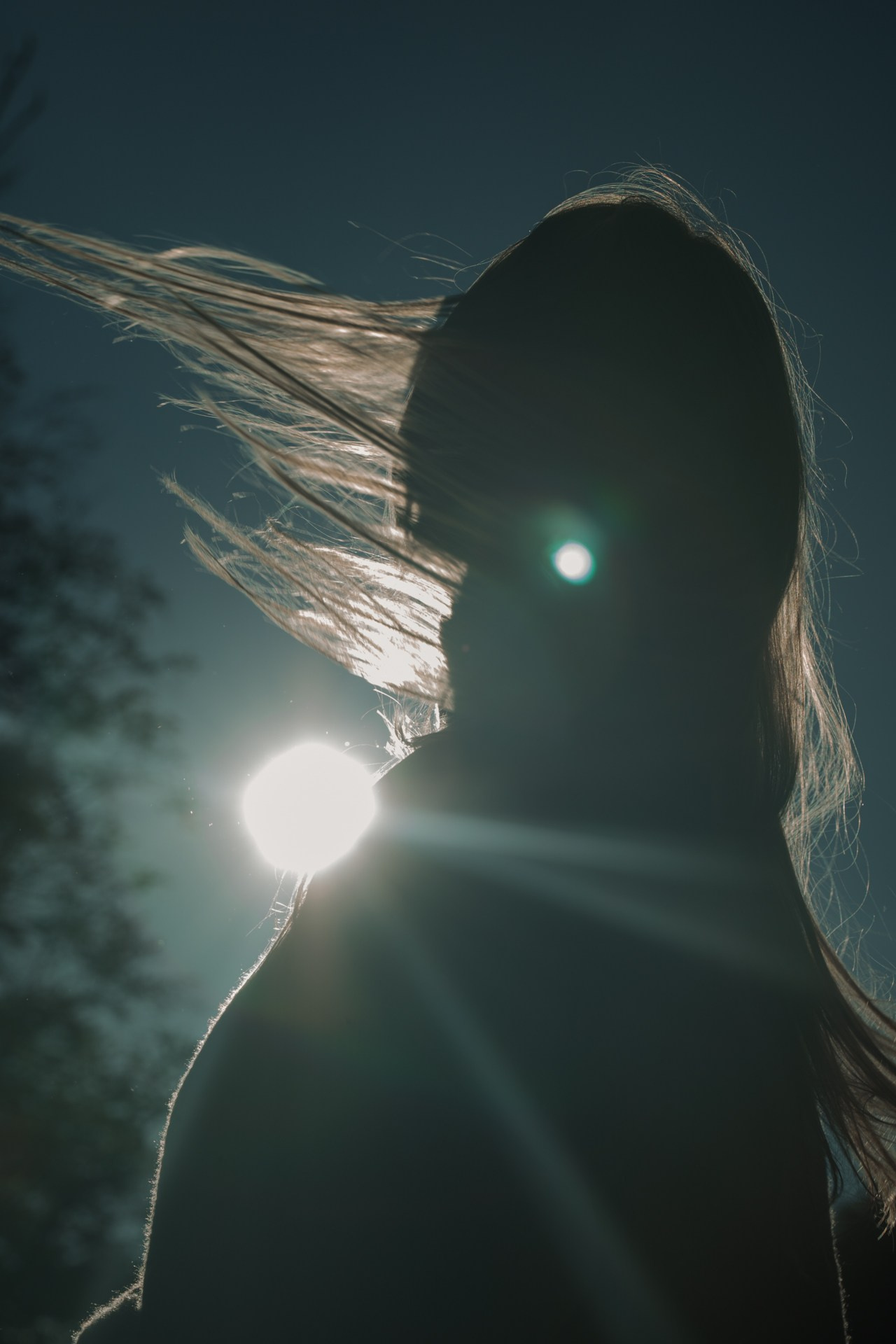 Силуэтная фотография девушки с  лучом солнца