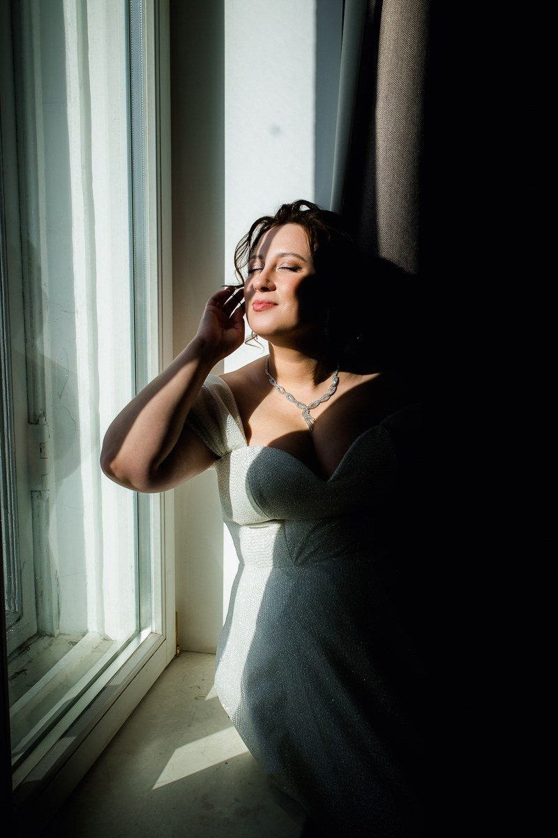 Невеста в отеле смотрит в окно на Казанский собор Петербурга