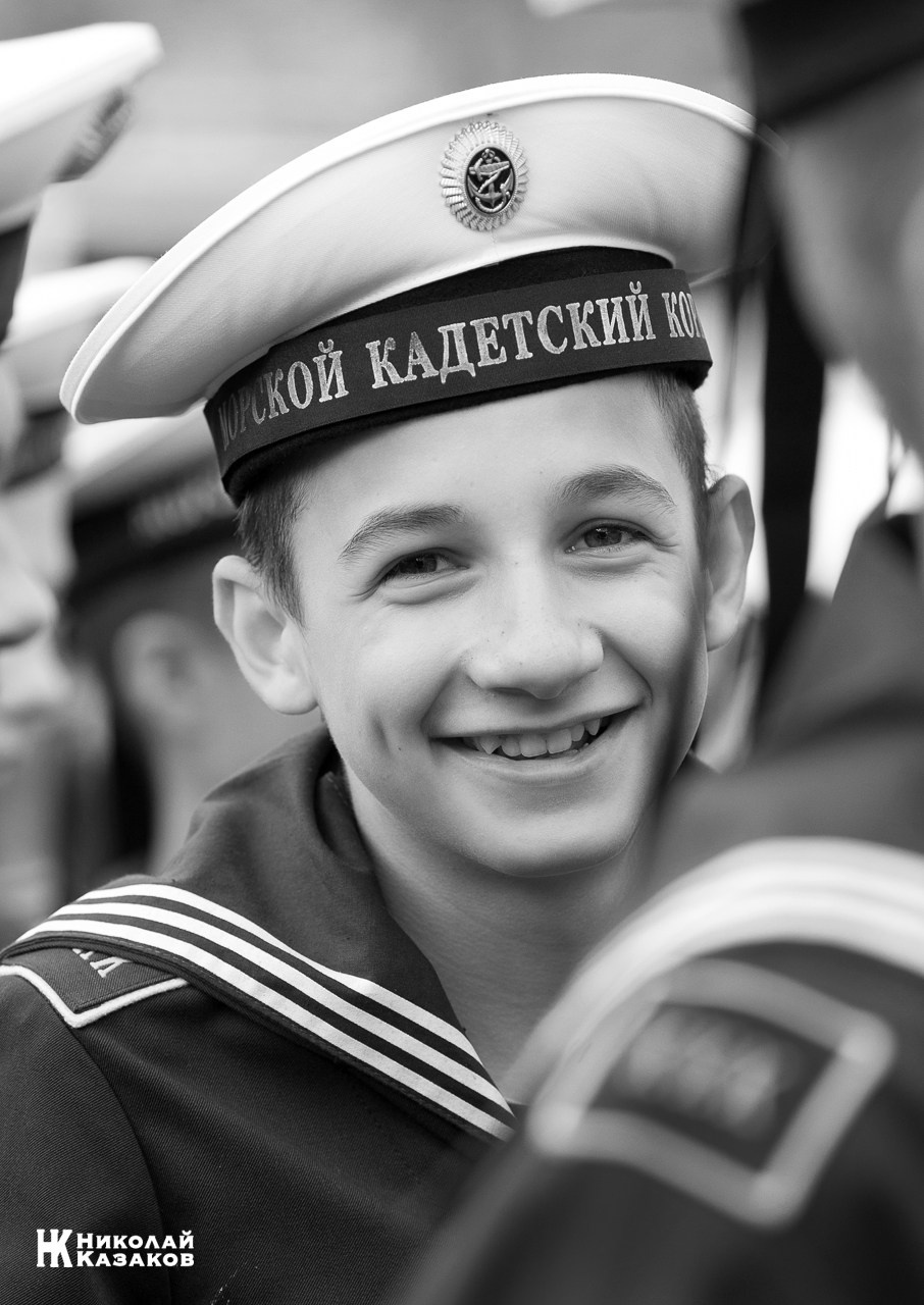 Черно-белый портрет смеющегося воспитанника Кронштадского морского кадетского военного корпуса на построении.