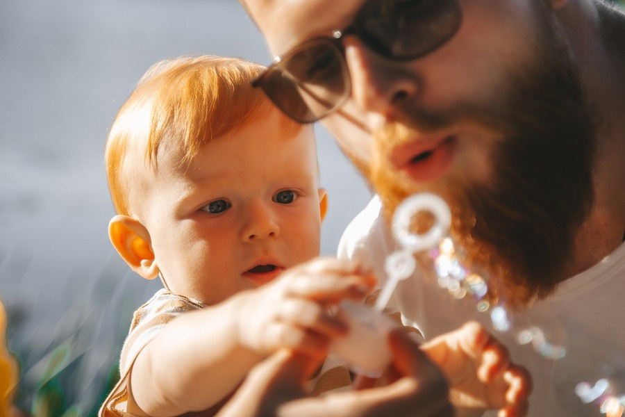 Папа и сын дуют мыльные пузыри