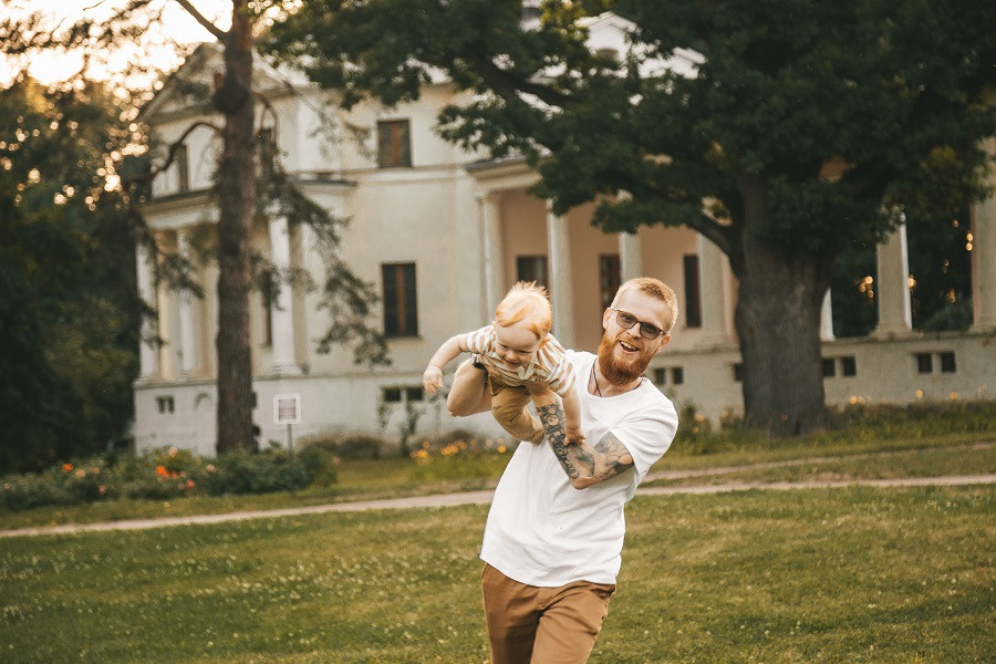 мужчина в белой футболки кружит ребенка