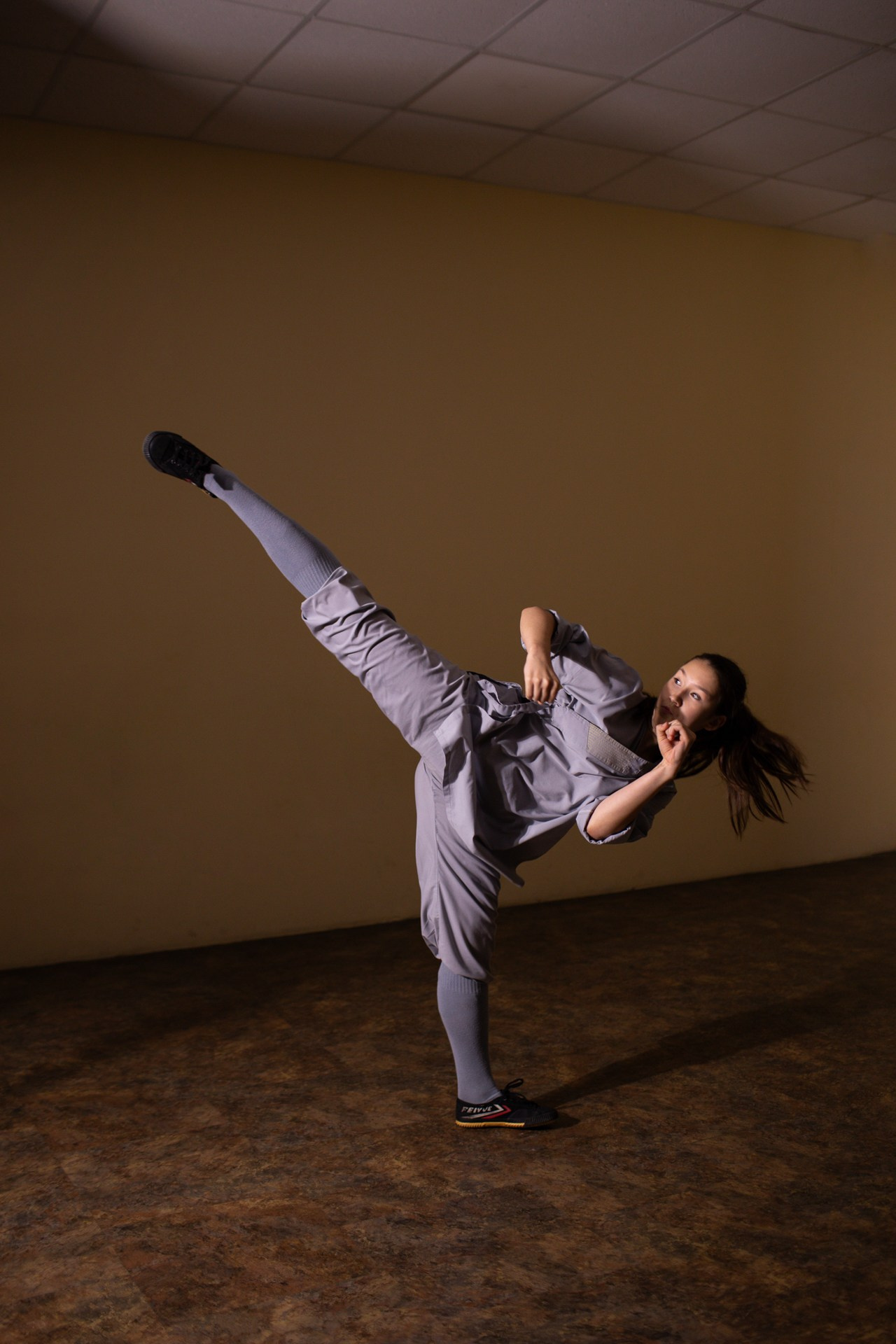 Высокий классный удар ногой. Ушу кунг-фу удар ногой. Девушка с хорошей растяжкой бьет ногой высоко.