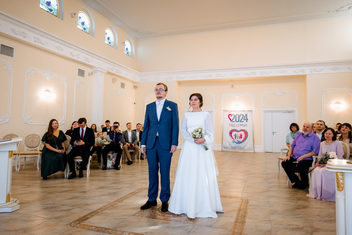 Жених и невеста стоят в зале регистраций ЗАГСа Красносельского района Санкт-Петербурга