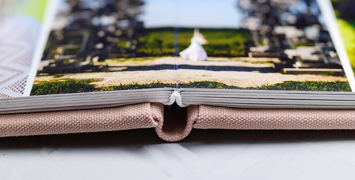 Детальный кадр раскрытого разворота на 180 градусов. Книга в тканевой обложке с мягкой фактурой, созданная для уютных семейных просмотров.