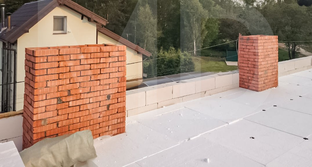 Кирпичные дымоходы на плоской кровле современного дома