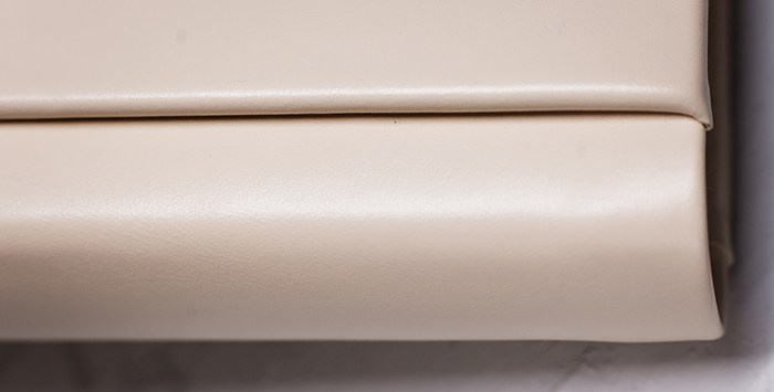 Крупный план переплета и корешка фотокниги. Видна качественная сборка плотных страниц и мягкая текстура экокожи нежно-бежевого оттенка.