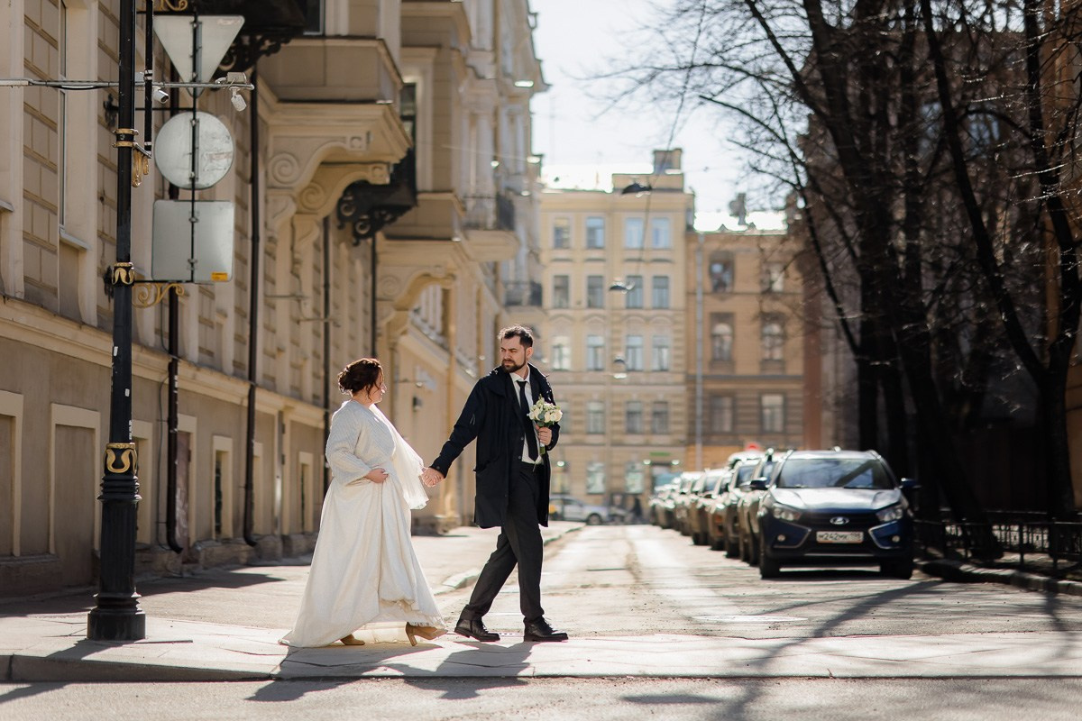 Жених и невеста прогуливаются по улице Санкт-Петербурга