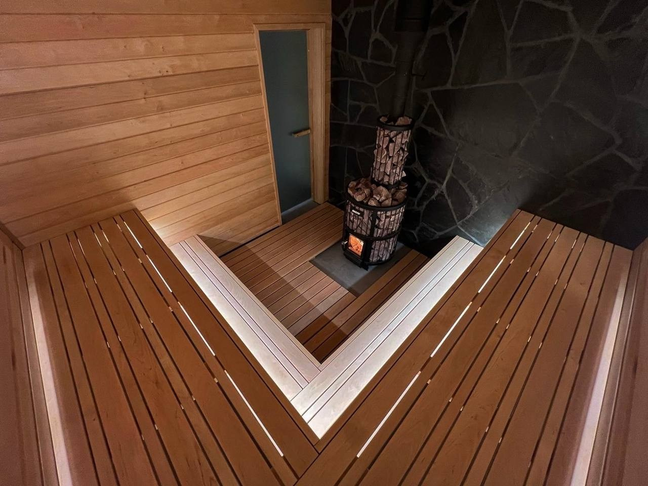 Эксклюзивная парная в Мендсарах из разнокалиберной светлой ольхи и шунгита, а внутренняя топка только усиливает эффект контраста. SaunaTopMasters