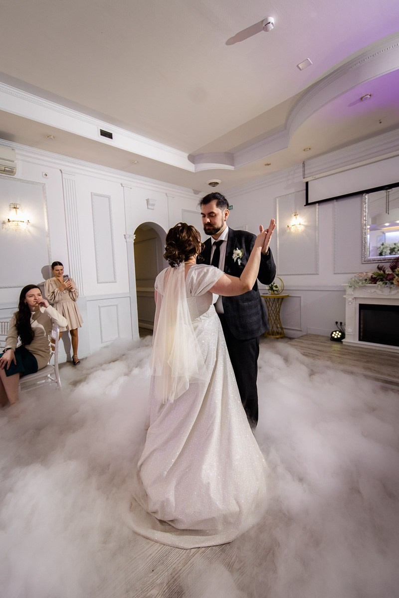 Жених и невеста танцуют первый танец в ресторане Санкт-Петербурга. Вертикальный кадр