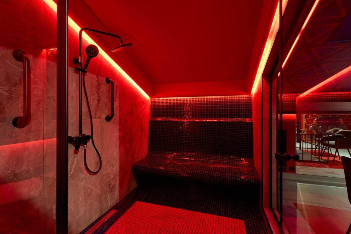 душ в красном свете в отеле для фотосъёмки в стиле ню