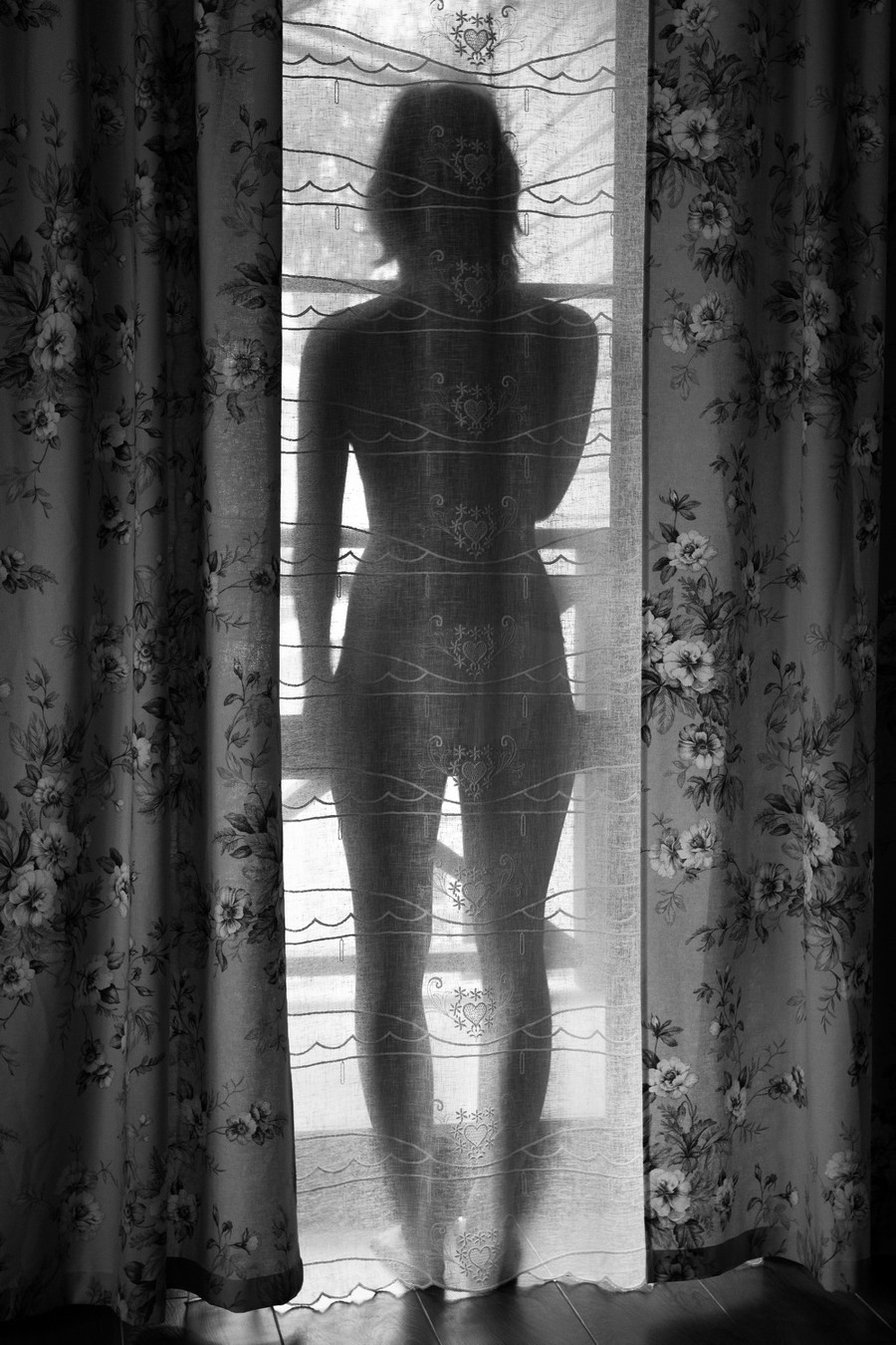 обнаженная женщина смотрит в окно