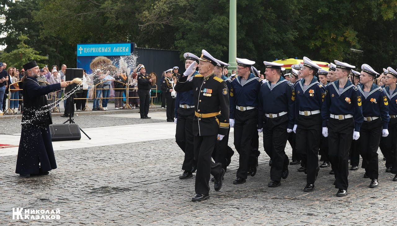 Священик благословляет святой водой кадетов  морского кадетского военного корпуса во время марша  по Якорной площади 