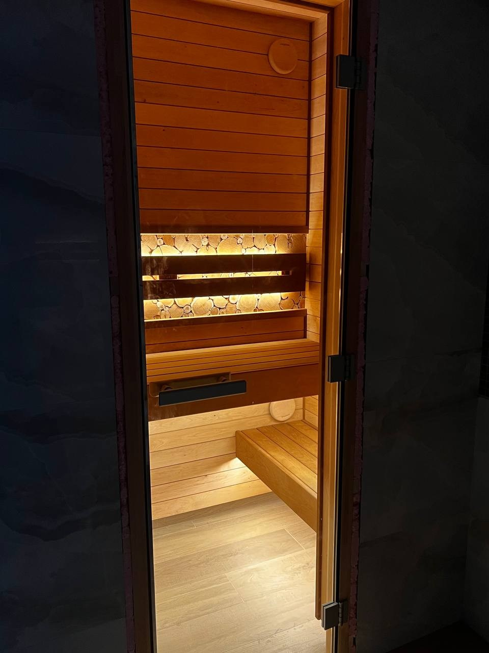 Уютная парная в Glorex Заневский. Компактная, но визуально просторная за счет парящих полков и горизонтального расположения светлой ольхи. SaunaTopMasters