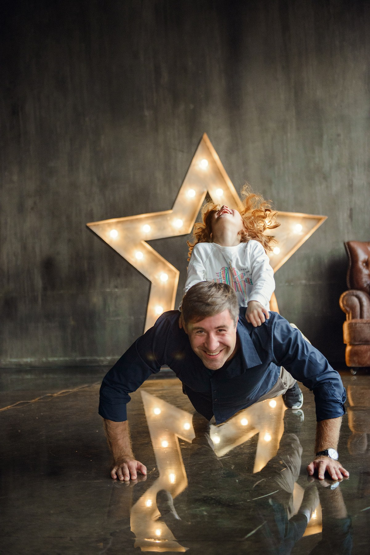 dad and daughter in a dark photo studio