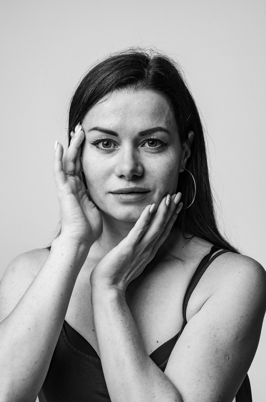 Черно-белый портрет молодой женщины крупным планом с веснушками