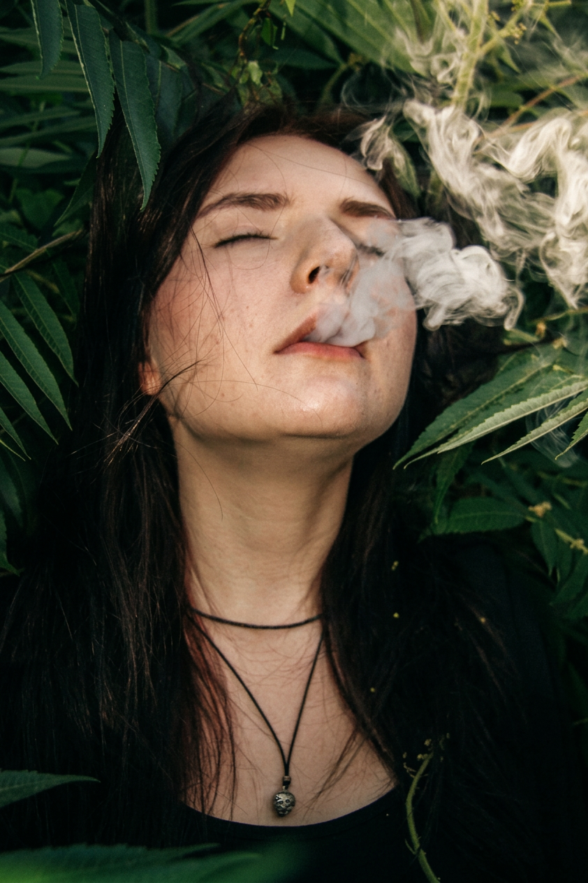 Летний портрет девушки на фоне куста с эффектом дыма