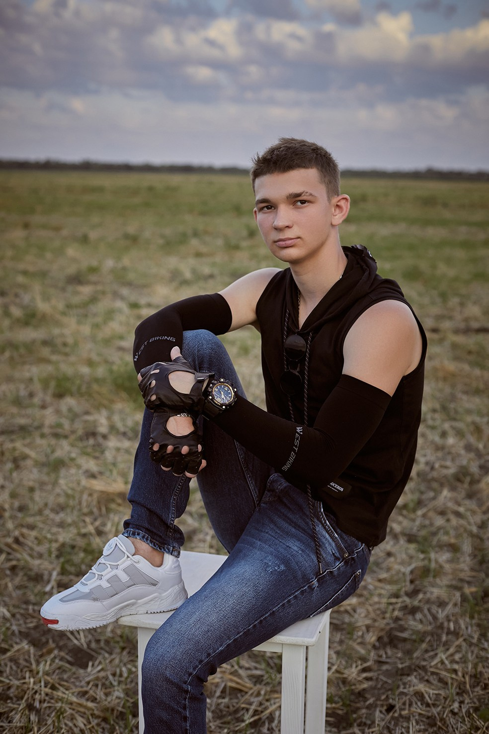 Фотограф в Москве. Креативное фото. Парень сидит на стуле в поле на закате.